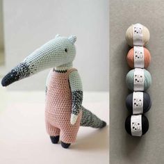 an animal made out of crochet next to some balls of yarn on the wall