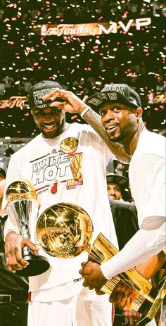 two men standing next to each other holding trophies and confetti in front of them