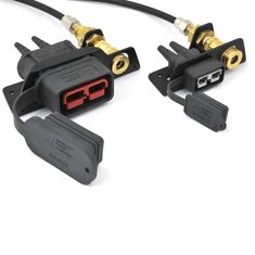 two black and gold plugs connected to each other on a white surface with wires