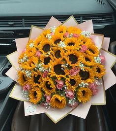 a bouquet of sunflowers and baby's breath in the passenger seat of a car