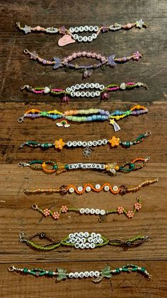 several bracelets are arranged on a wooden surface with beads and flowers in the middle