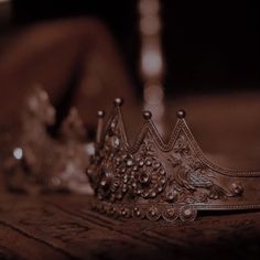 two silver crowns sitting on top of a wooden table