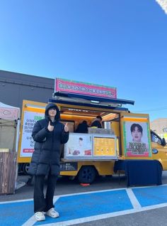 a woman standing in front of a food truck giving the thumbs up