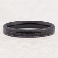 an image of a black wedding band with wood inlays on the inside of it