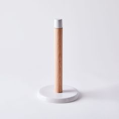 a white and wooden object on a white surface with a light brown stick sticking out of it