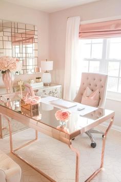 a white desk with pink flowers on it in front of a large mirror and window