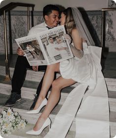 a bride and groom are sitting on the stairs with newspapers in their hands as they look at each other