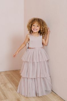 A chic take on a timeless style, our Breely Flower Girl dress is the perfect addition to your wedding line-up! Breely features a modest satin top with a three-tiered tulle skirt creating the perfect dress for your little one to twirl the night away! Breely is finished off with a low v-back and an oversized satin bow. M Confirmation Tulle Princess Dress With Ruffles, Tulle Princess Dress With Ruffles For Confirmation, Confirmation Princess Dress With Tulle Ruffles, Tiered Tulle Tutu Dress For Dress-up, Tiered Princess Dress For Wedding, Tiered Tulle Skirt Dresses For Dress-up, Tiered Tulle Tutu Dress, Bridesmaid Tiered Tulle Dress, Kids Tulle Dress