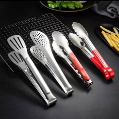 five kitchen utensils lined up next to each other on a black countertop