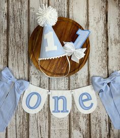 a blue and white first birthday banner with the number one on it