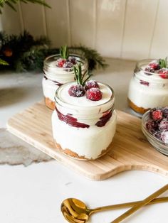 small desserts are sitting on a cutting board with gold spoons and greenery