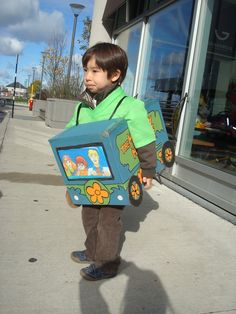 a young boy is holding a cardboard box