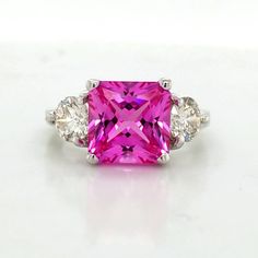 GORGEOUS vintage 14K WHITE GOLD engagement ring pink sapphire in radiant shape center lab grown sapphire weight 4.55carat . size 9x9mm very nice vivid pink color , nice luster, very lively ,nice cut. clean.sparkly sapphire . side two natural round cut diamonds total weight 1.02ct. Size 5.2mm H-SI1 ring size 6 Resizable Appraisal available Retail value $6,950net. Gold Engagement Ring Radiant Cut, Engagement Ring Radiant Cut, Engagement Ring Pink, Engagement Ring Radiant, Platinum Engagement Rings Vintage, Pink Stone Rings, Pink Engagement Ring, Pink Sapphire Ring Engagement, Yellow Gems