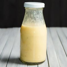 a glass bottle filled with liquid sitting on top of a wooden table