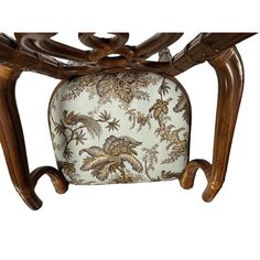 an ornately carved wooden bench with floral upholster