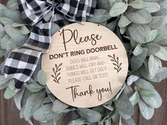 a wooden plaque that says please don't ring dobble on the front of a wreath