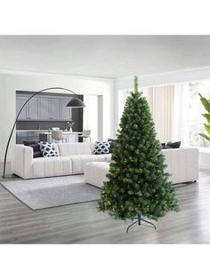 a living room with white furniture and a christmas tree in the middle of the room