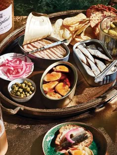 a tray filled with different types of food on top of a table next to wine bottles