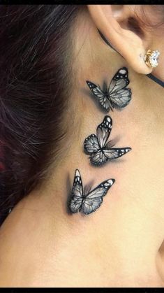 a woman's neck with three butterflies on the back of her neck and behind her ear