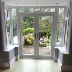 an empty room with double doors and windows