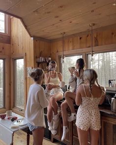 three women are sitting on the counter in a cabin