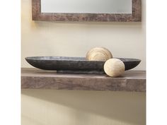 a wooden bowl sitting on top of a shelf next to a mirror and two other items