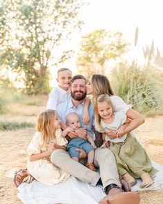 a family sitting together on a blanket in the grass