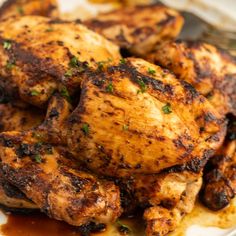 grilled chicken with sauce and herbs on a plate