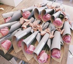 a bunch of flowers that are sitting on some kind of table cloth with paper wrapped around them