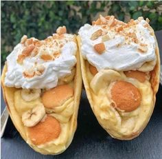 two banana split desserts with whipped cream and bananas on top, one is cut in half