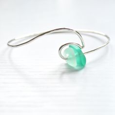 This sterling silver ocean wave bracelet is accented with cultured sea glass in beautiful hues of green. Bracelet is made with 14g sterling silver wire and hammered for a textured look. Each piece is hand formed, which adds to its unique and original quality, so please allow for slight variations. **Please also allow for variations in size and shape of sea glass** Wire Wrapped Silver Recycled Glass Jewelry, Wire Wrapped Silver Jewelry With Recycled Glass, Handmade Sea Glass Bracelet As Gift, Handmade Sea Glass Bracelet For Gift, Adjustable Wavy Sterling Silver Jewelry, Nickel-free Green Sterling Silver Bracelets, Elegant Green Sea Glass Jewelry, Hand Wrapped Green Sterling Silver Jewelry, Unique Green Sterling Silver Bracelets