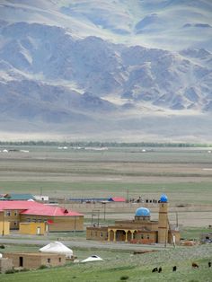 a small town in the middle of nowhere with mountains in the backgrouds