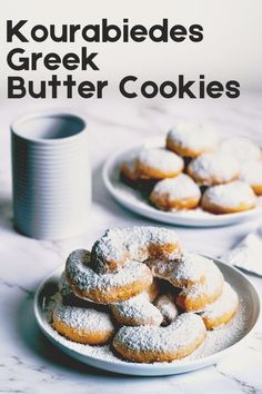 two plates with powdered sugar covered doughnuts on them next to a cup of coffee