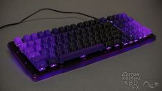 a purple and black keyboard sitting on top of a table