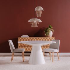 a white table with four chairs around it and a plant in the corner next to it