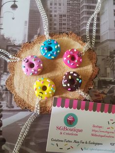 four doughnuts with sprinkles on them are hanging from a chain