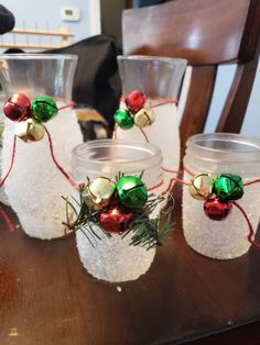 three glass vases with christmas decorations on them