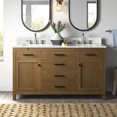 a bathroom with two round mirrors above the sinks and a rug in front of it