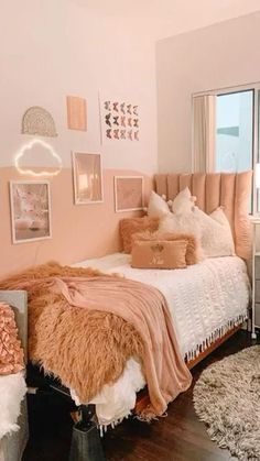 a bedroom decorated in pink and white with pictures on the wall, rugs and bedding