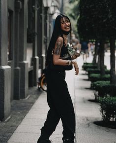 a woman is walking down the sidewalk and smiling