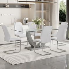 a glass dining table with white chairs and a vase on the end in front of it