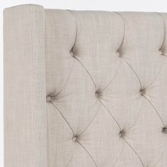 an upholstered headboard with buttons on the top and bottom, in beige linen