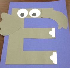 the letter e is made out of paper with eyes and hands on it's side