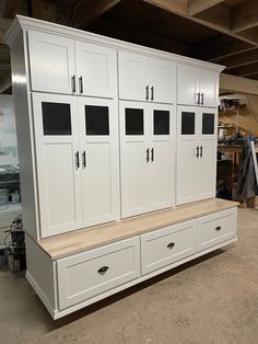 a large white cabinet with drawers in a garage