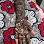 a woman's hand is decorated with henna and red flower designs on it