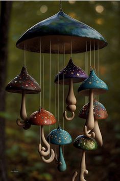 a group of mushrooms hanging from strings in the forest with rain drops coming out of them