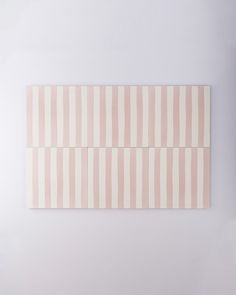 two pieces of pink and white striped paper on a wall with one piece cut out