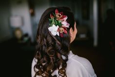 the back of a woman's head with flowers in her hair