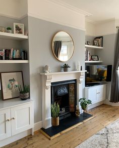 a living room filled with furniture and a fire place in front of a tv mounted on a wall