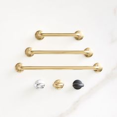 brass handles and knobs on a white marble countertop, with three different colors